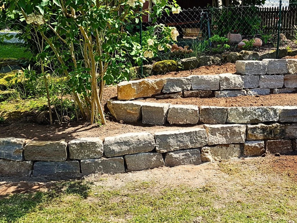 Runde Trockenmauer aus Natursteinen mit abgestuften Ebenen
